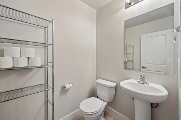 Half bathroom with toilet and baseboards