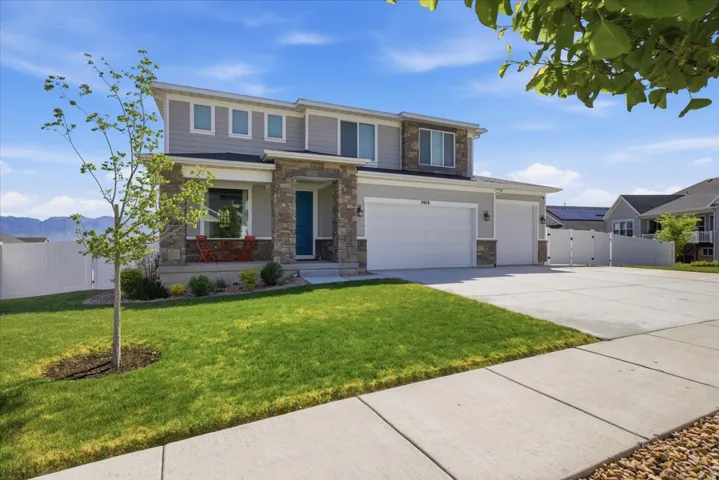 Modern two-story home featuring stone and siding exterior, a three-car garage, and a concrete driveway