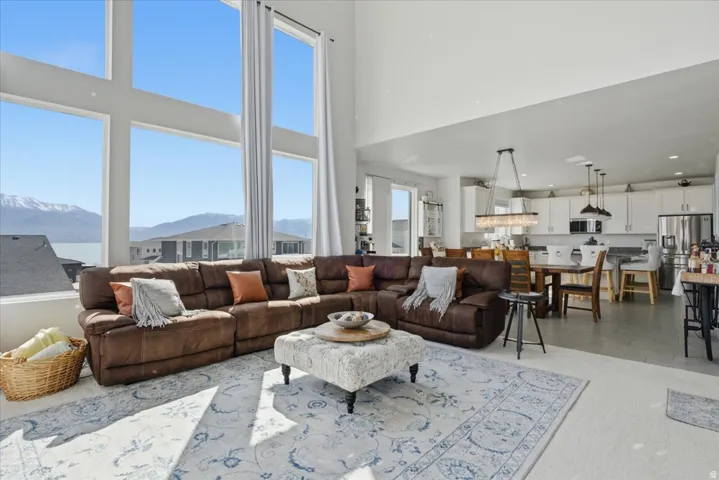 Two-story windows frame mountain and water scenery in this open-concept living space