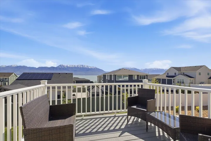 Outdoor deck featuring a white railing system, composite decking, and a backdrop of distant mountains and water