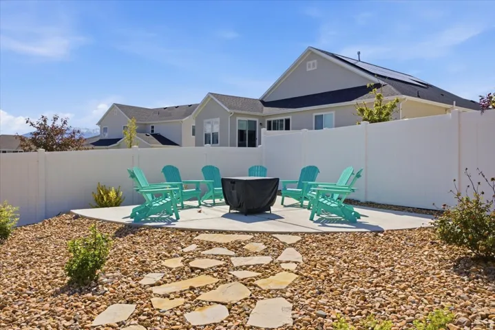 Outdoor patio area featuring a concrete pad, a flagstone pathway, and surrounding gravel landscaping