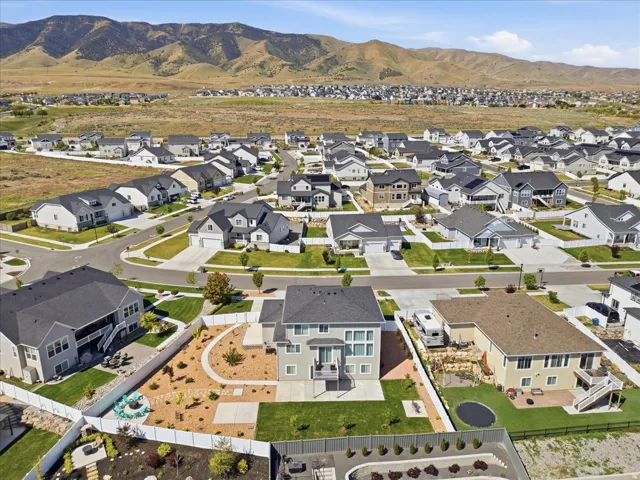 Aerial perspective showcasing a residential community with varied home styles and expansive mountainous terrain