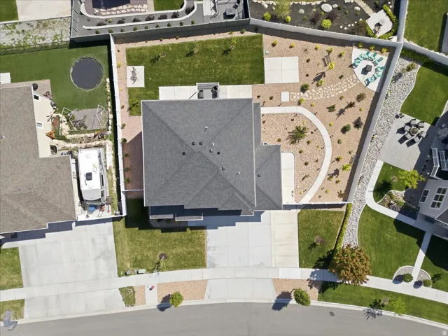 Aerial perspective highlighting a multi-level roofline, extensive paved driveway, and varied landscaping