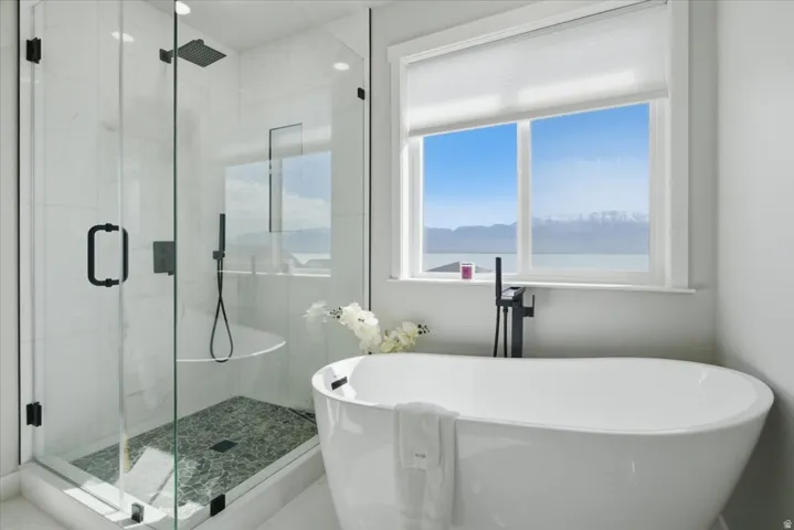 Freestanding soaking tub with a floor-mounted matte black faucet