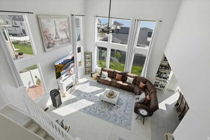 Two-story living area with high ceilings, multiple large windows, and a built-in fireplace