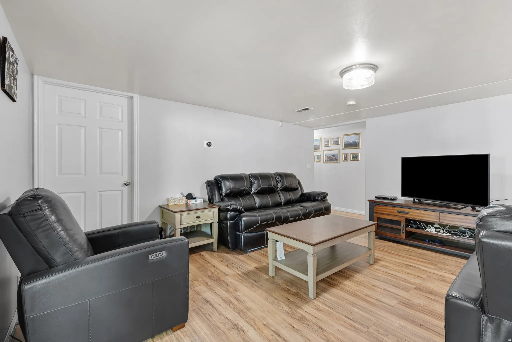 Open concept living area featuring wood-finish flooring and white walls