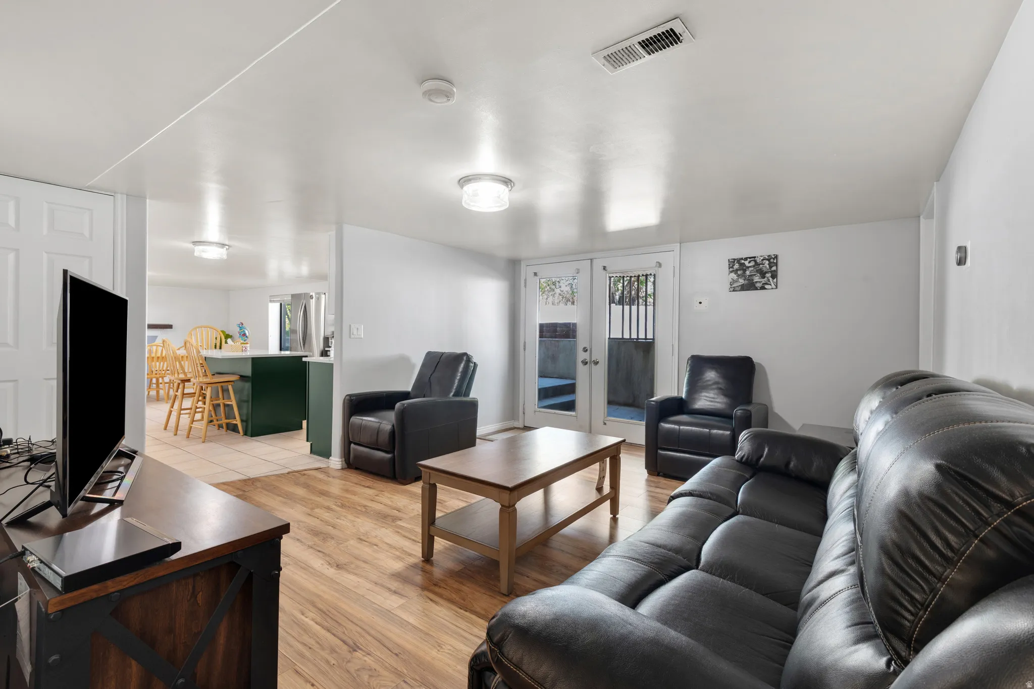 Interior living area featuring wood-finish flooring, white walls, and recessed lighting