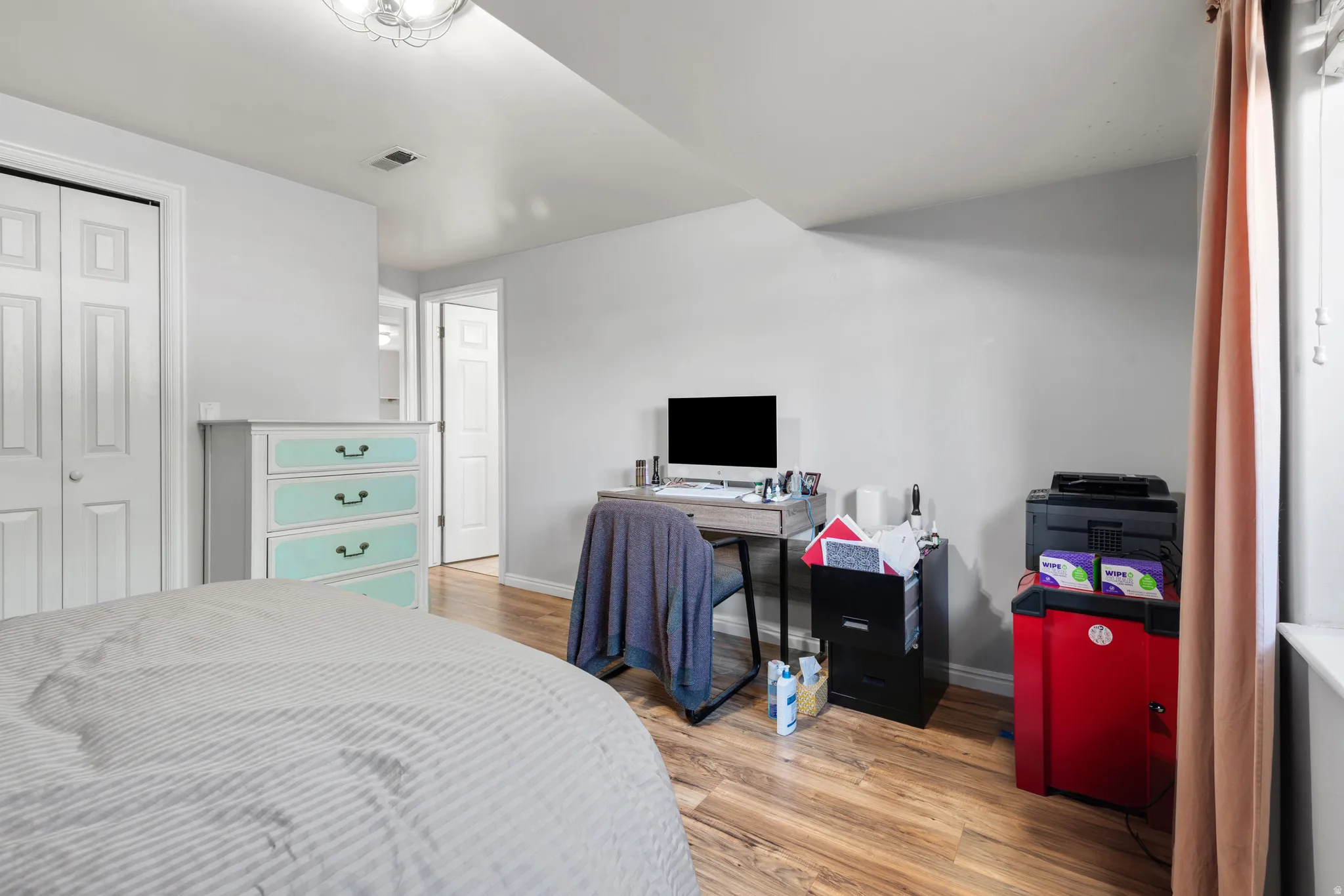 Bedroom featuring wood-finish flooring, light-toned walls, and a ceiling-mounted light fixture