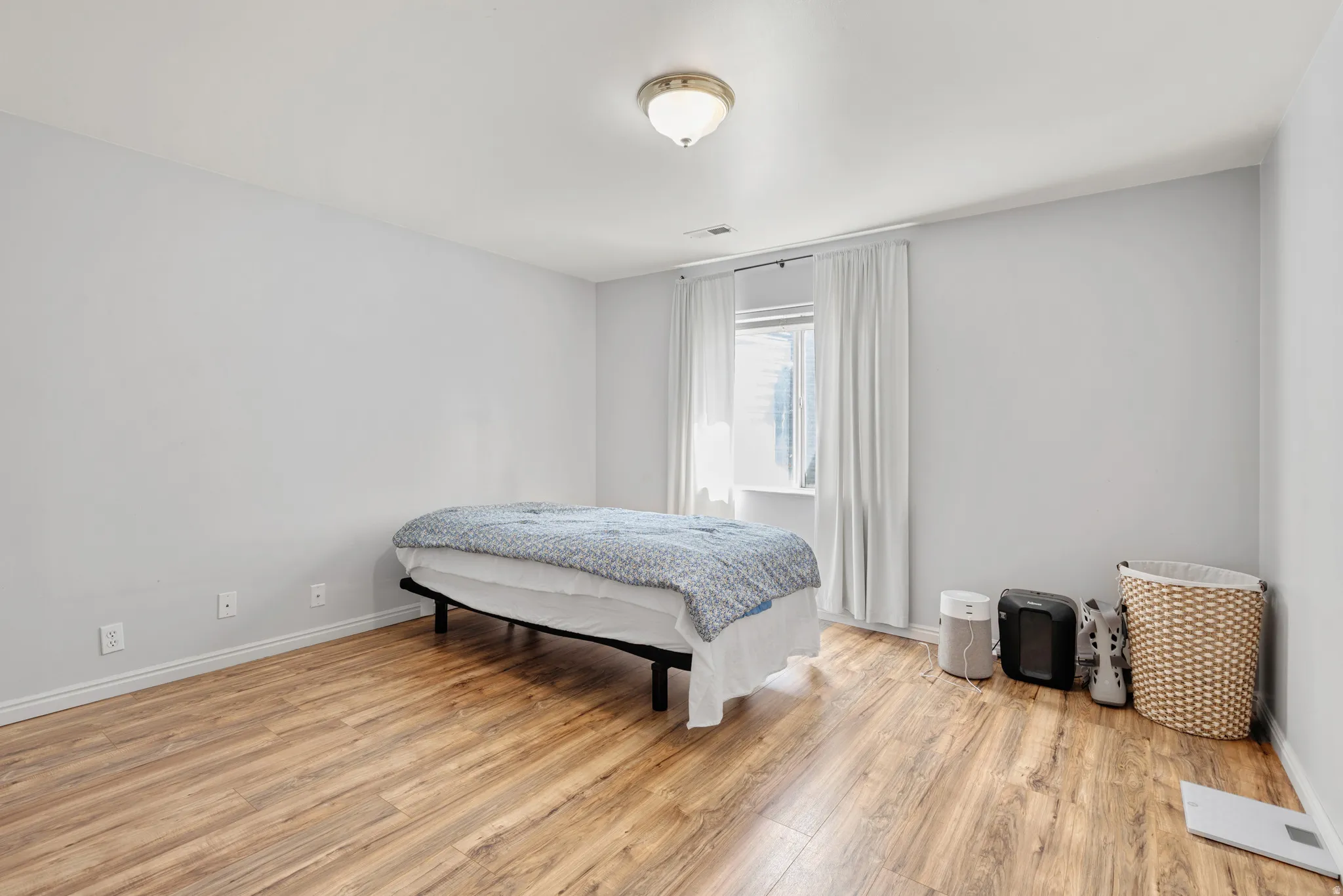 Room featuring wood-finish flooring, light gray wall paint, and white trim