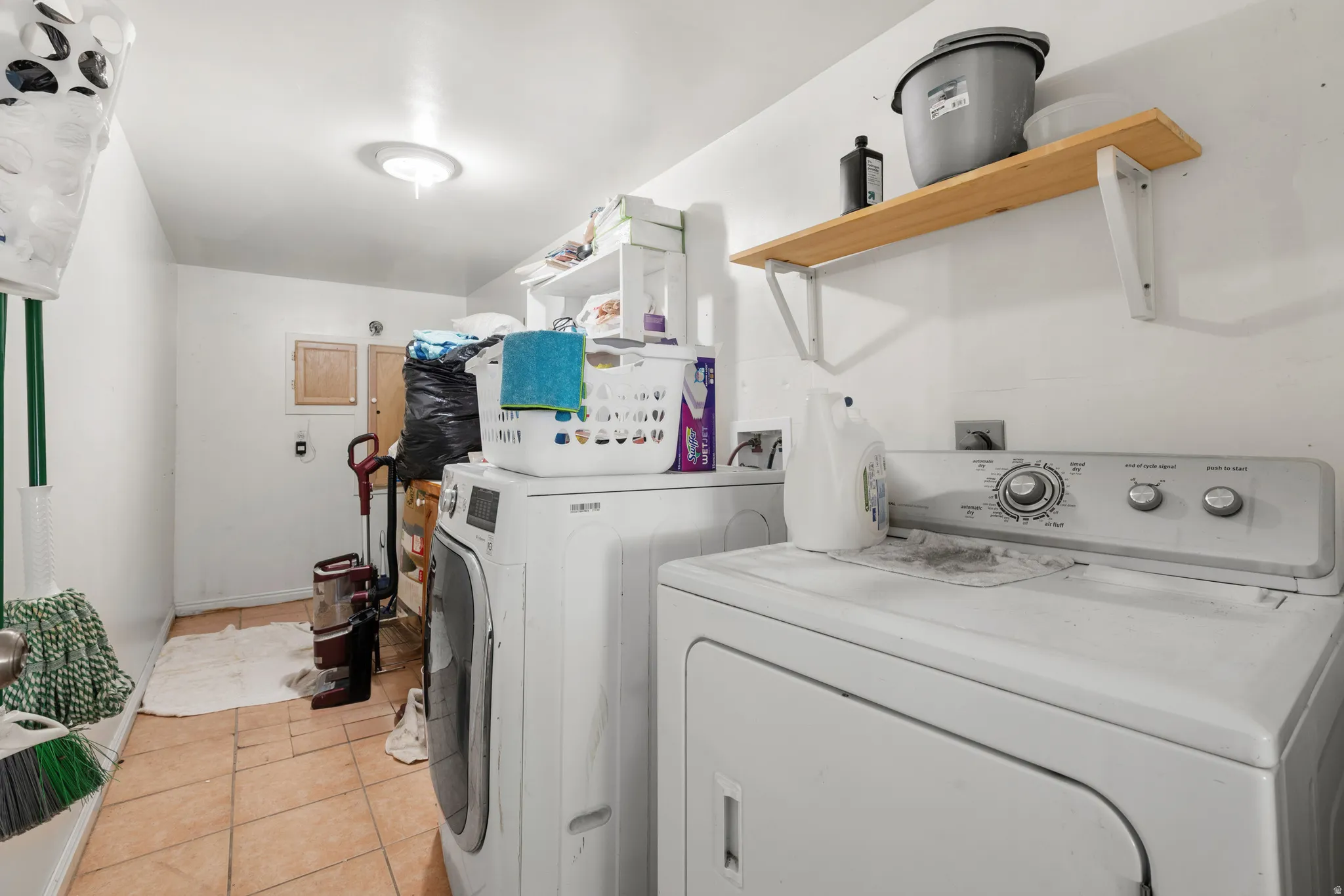 Laundry area featuring tile flooring and overhead lighting