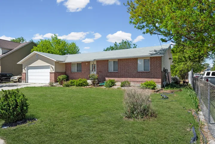 Brick and siding exterior featuring an attached garage and a concrete driveway