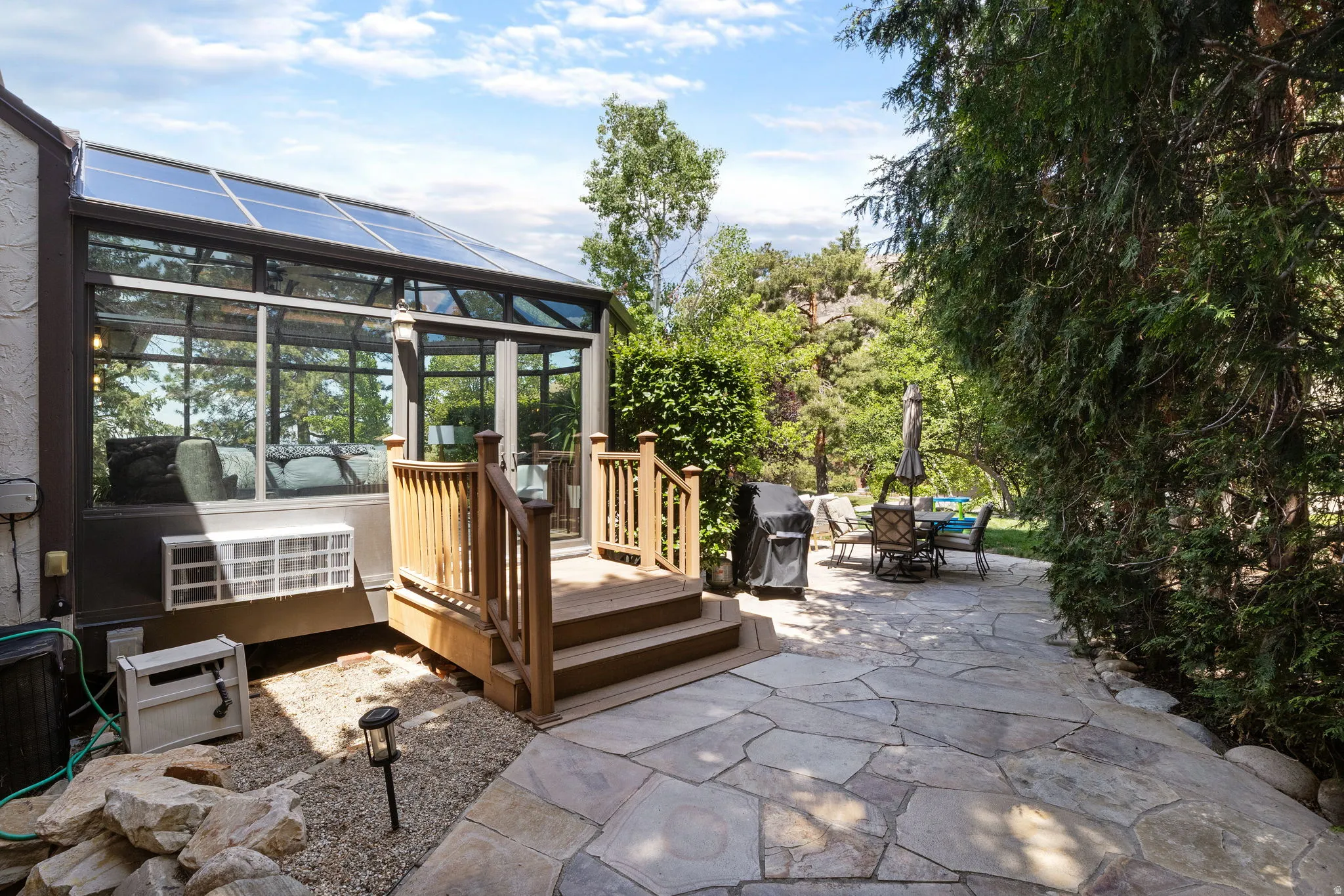 Sunroom addition featuring a glass roof and large windows