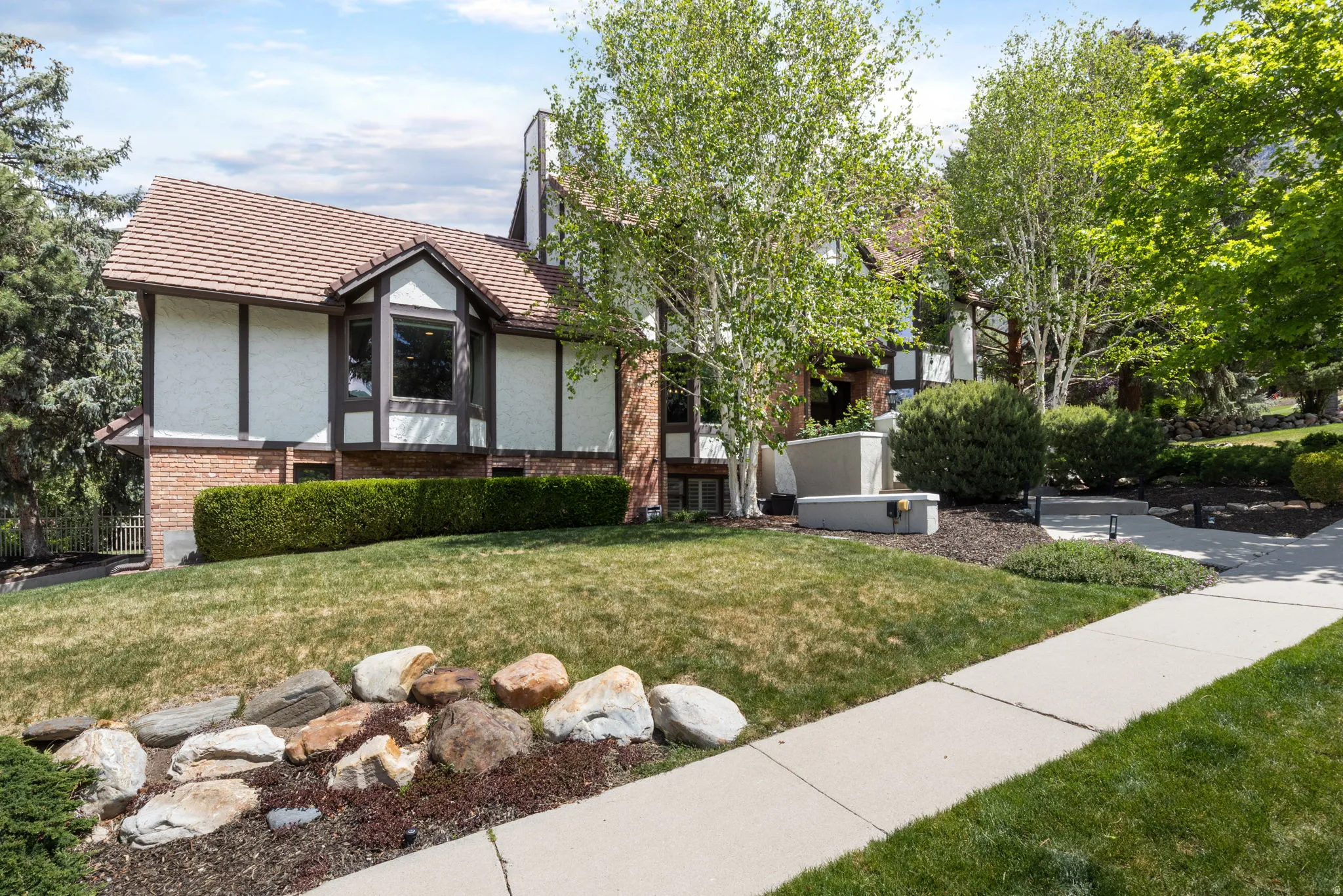 Exterior facade featuring a bay window, stucco siding, and brick accents