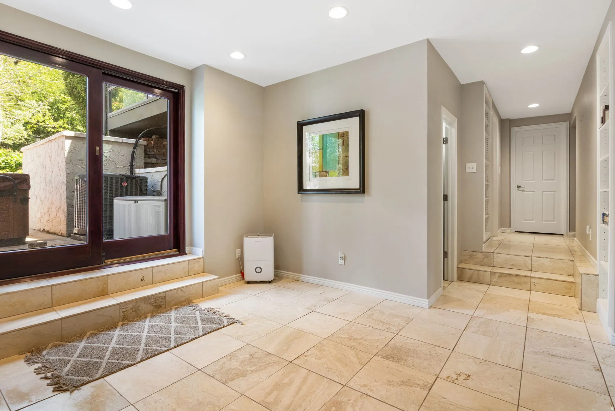Tiled flooring throughout with recessed lighting, offering a sliding glass door exterior access.  Walk out access
