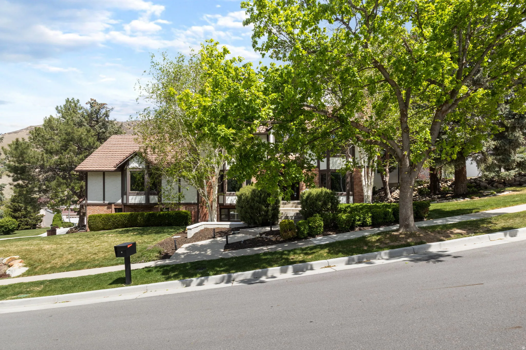 Traditional-style residence with a tiled roof, brick facade, and prominent bay windows