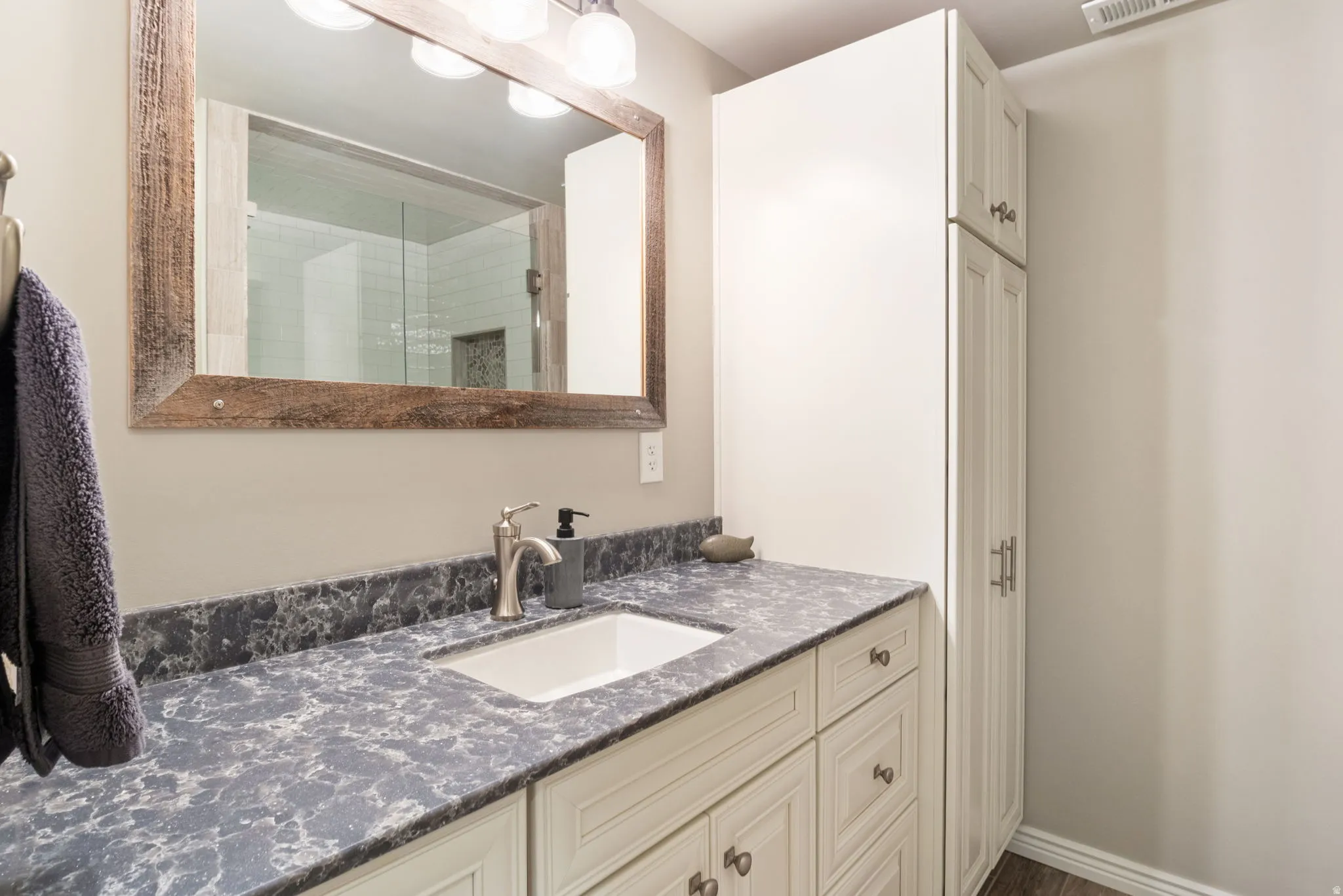 Bathroom vanity featuring an integrated sink, patterned countertop, and brushed nickel faucet