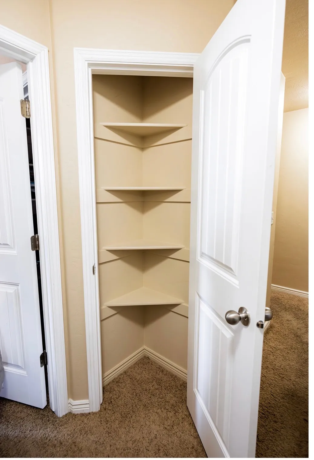 Corner pantry with multiple built-in shelves and coordinating trim