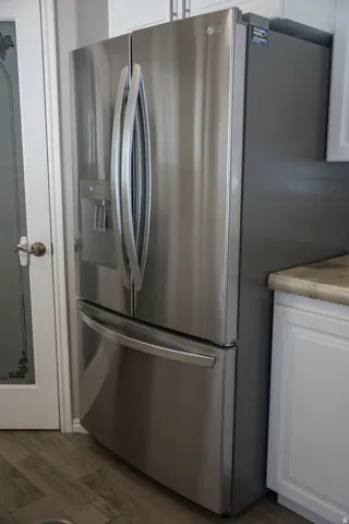 Stainless steel French door refrigerator with bottom freezer and integrated ice/water dispenser