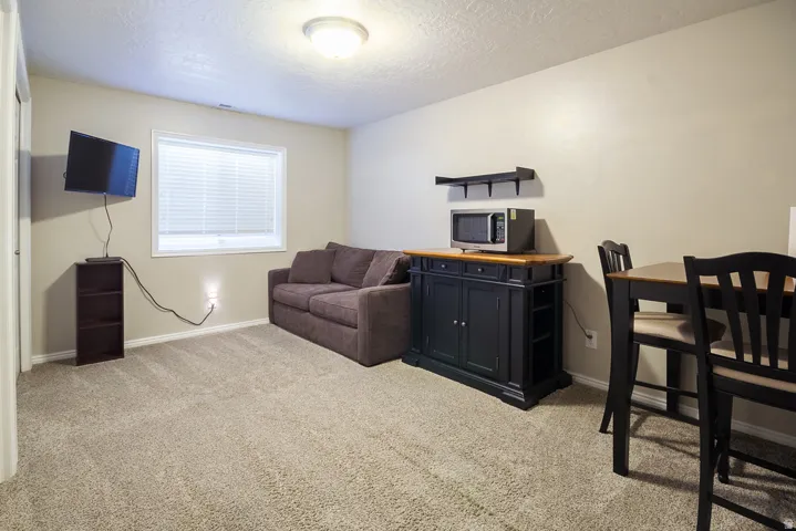 Carpeted room featuring a single window with blinds, a built-in light fixture, and a neutral wall color