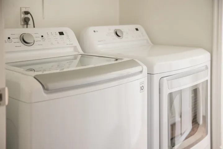 Dedicated laundry area featuring a white top-load washer and a white front-load dryer