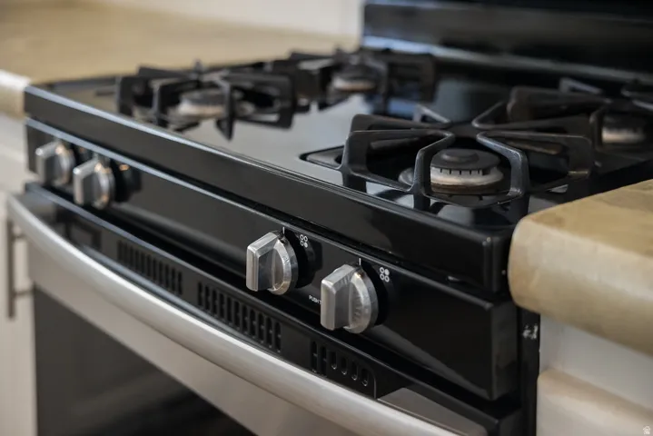 Built-in gas range featuring a black cooktop, cast iron grates, and stainless steel control knobs