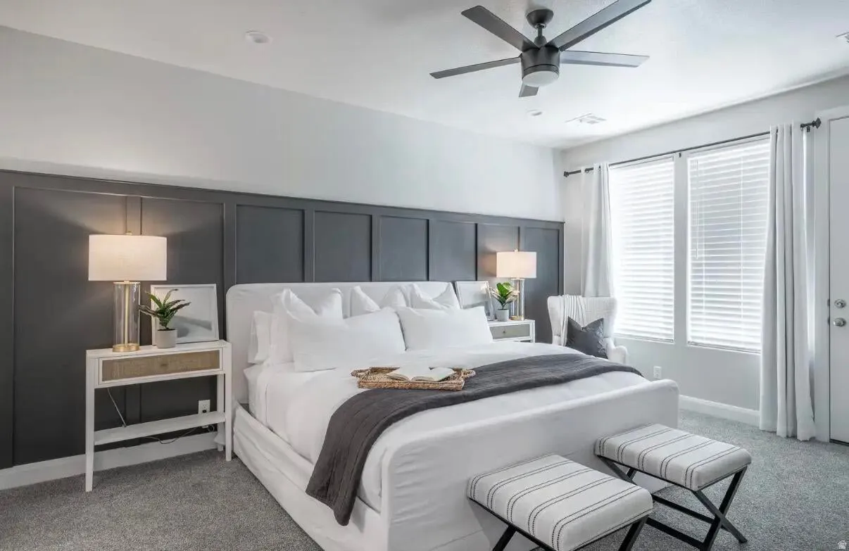 Room featuring a dark paneled accent wall, a ceiling fan with integrated lighting, and carpeted flooring