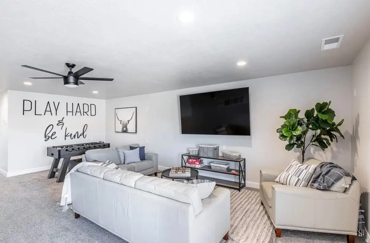 Spacious recreational area featuring recessed lighting, a modern ceiling fan, and carpeted flooring