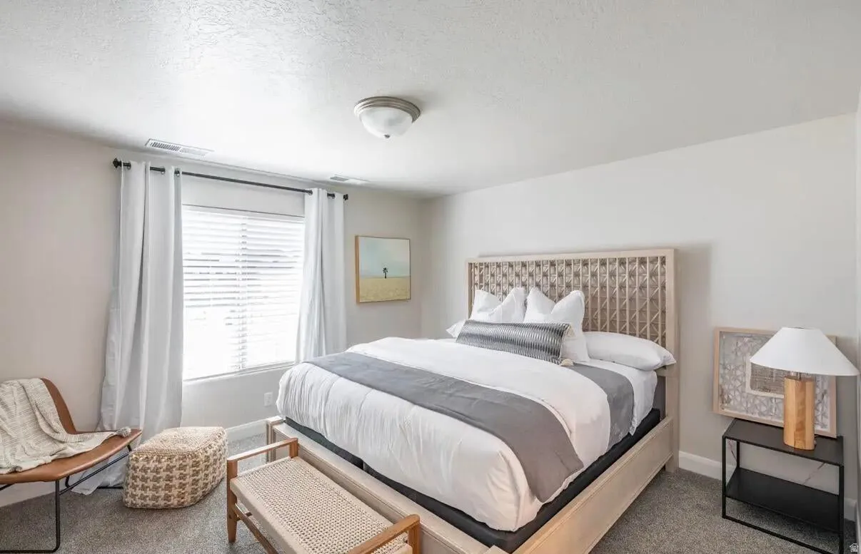 Bedroom featuring a light-toned wood-frame bed with an open geometric headboard