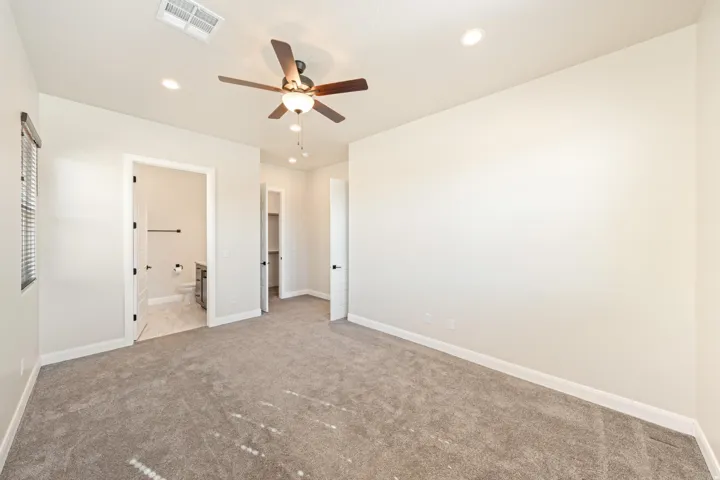 Carpeted room featuring a ceiling fan with integrated lighting, recessed lighting, and a window with blinds