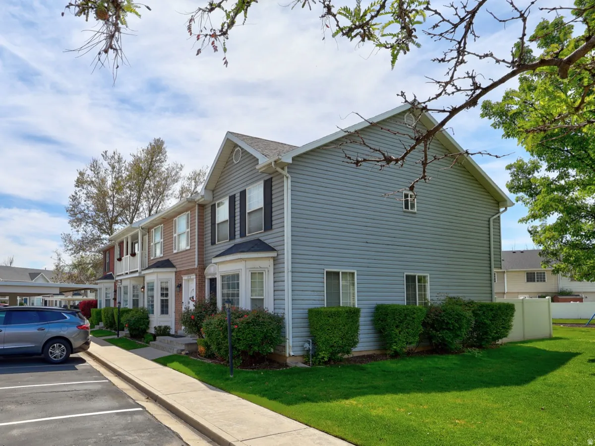Multi-level residential exterior featuring siding facade, bay windows, and a manicured lawn
