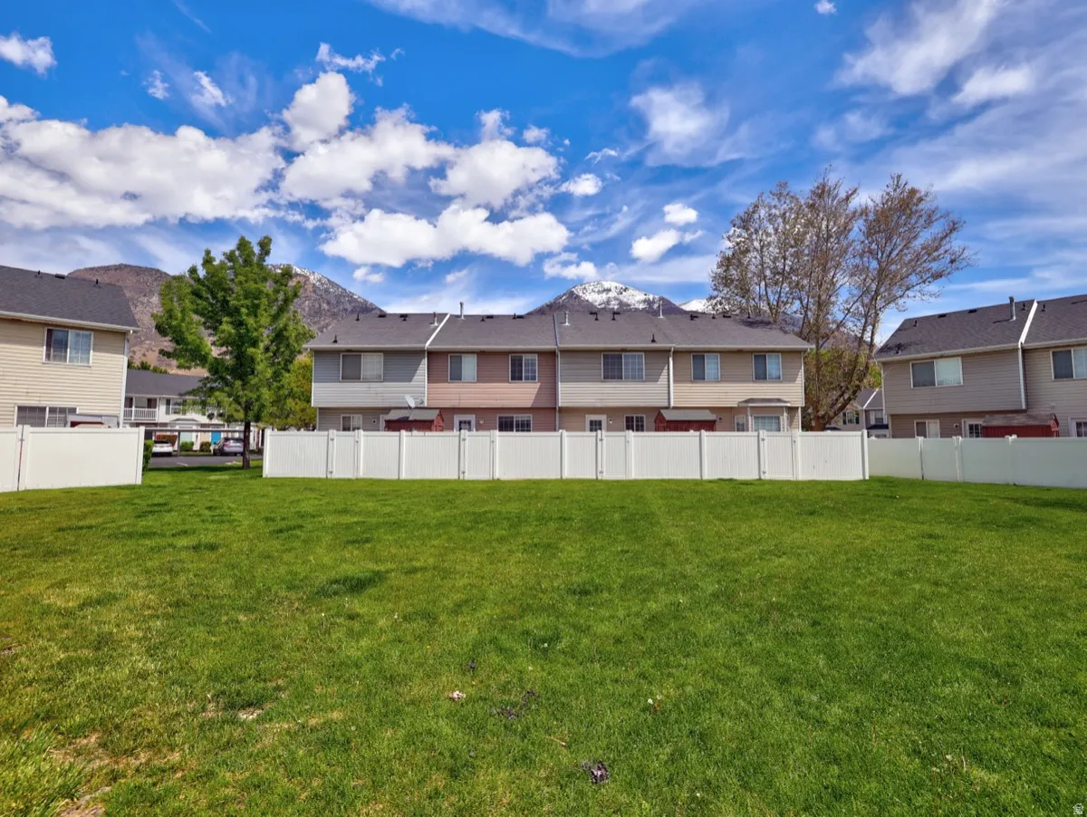 Expansive green lawn with a white vinyl privacy fence