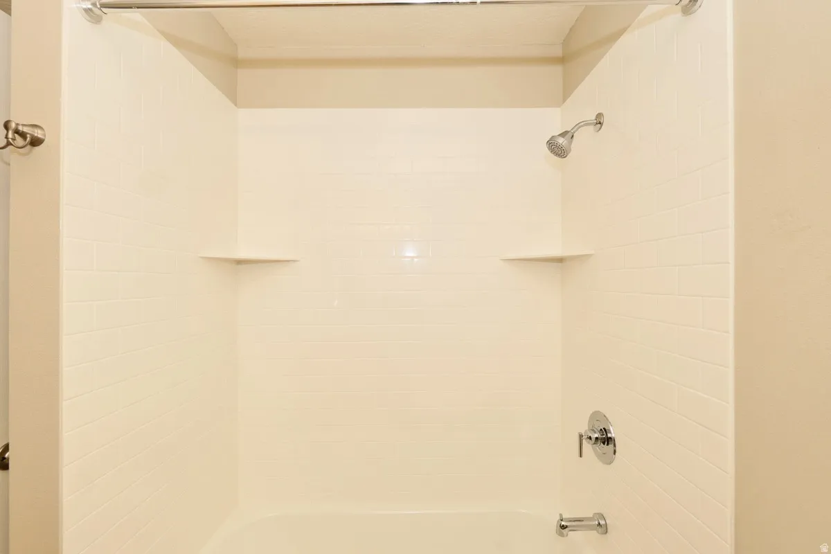 White subway tile shower surround with integrated corner shelves