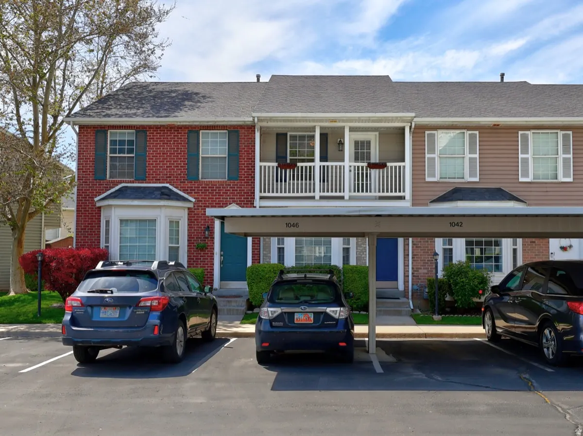 Multi-story townhouse exterior featuring a brick facade, bay window, and a covered balcony