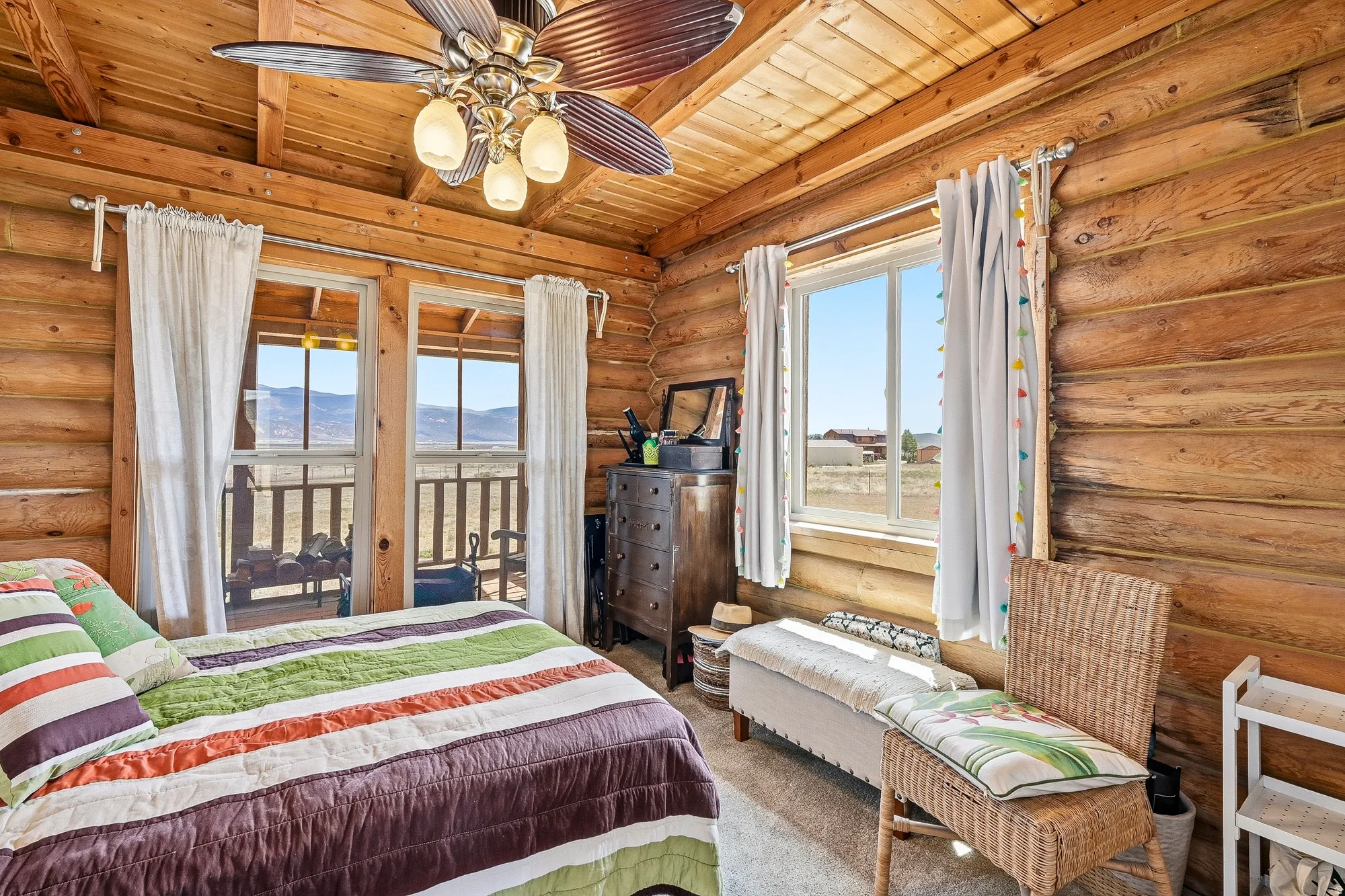 Wood-paneled interior featuring a log wall finish, wood ceiling, and exposed wood beams