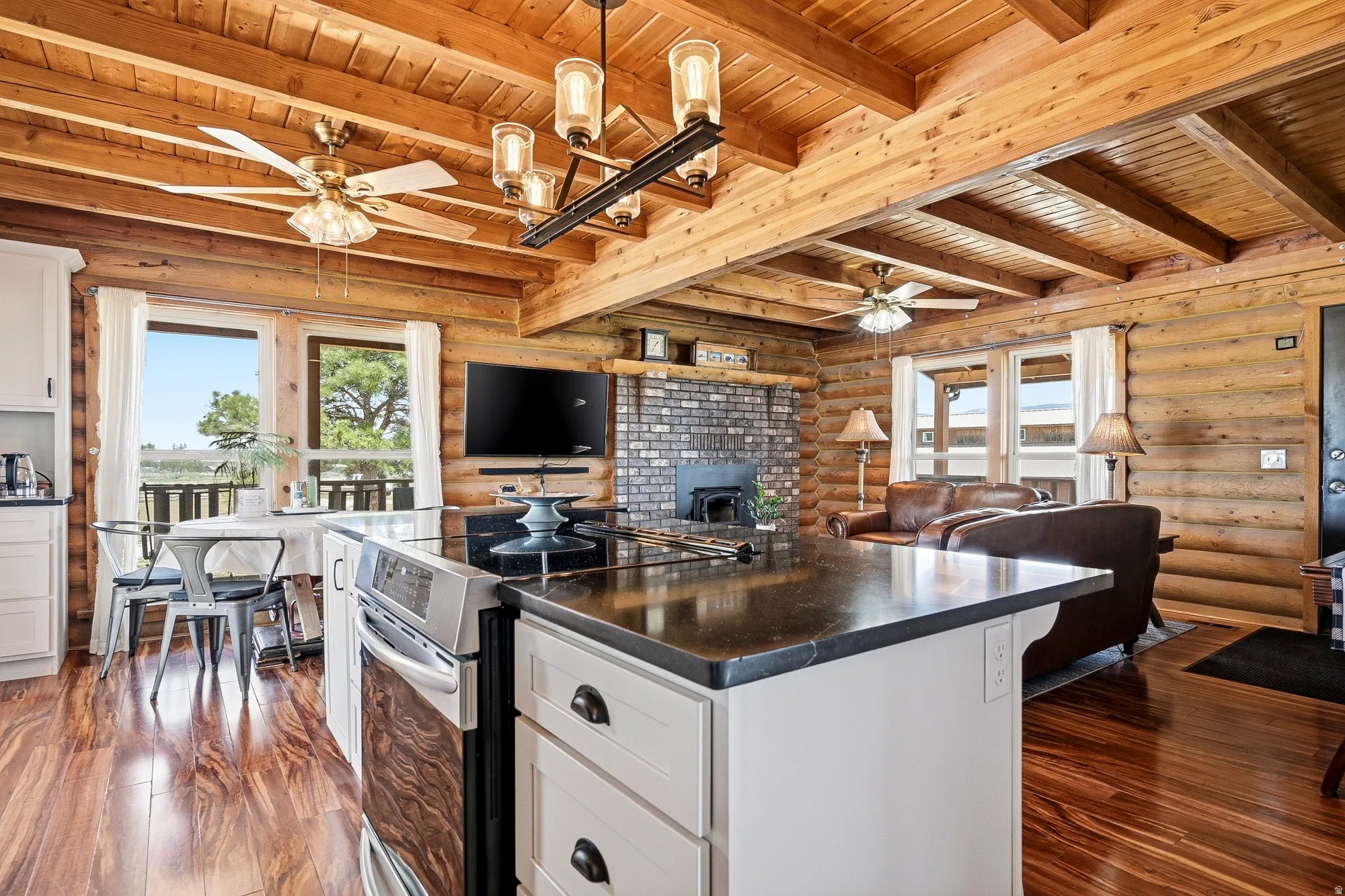 Open concept living space featuring a central kitchen island with a dark countertop and integrated oven