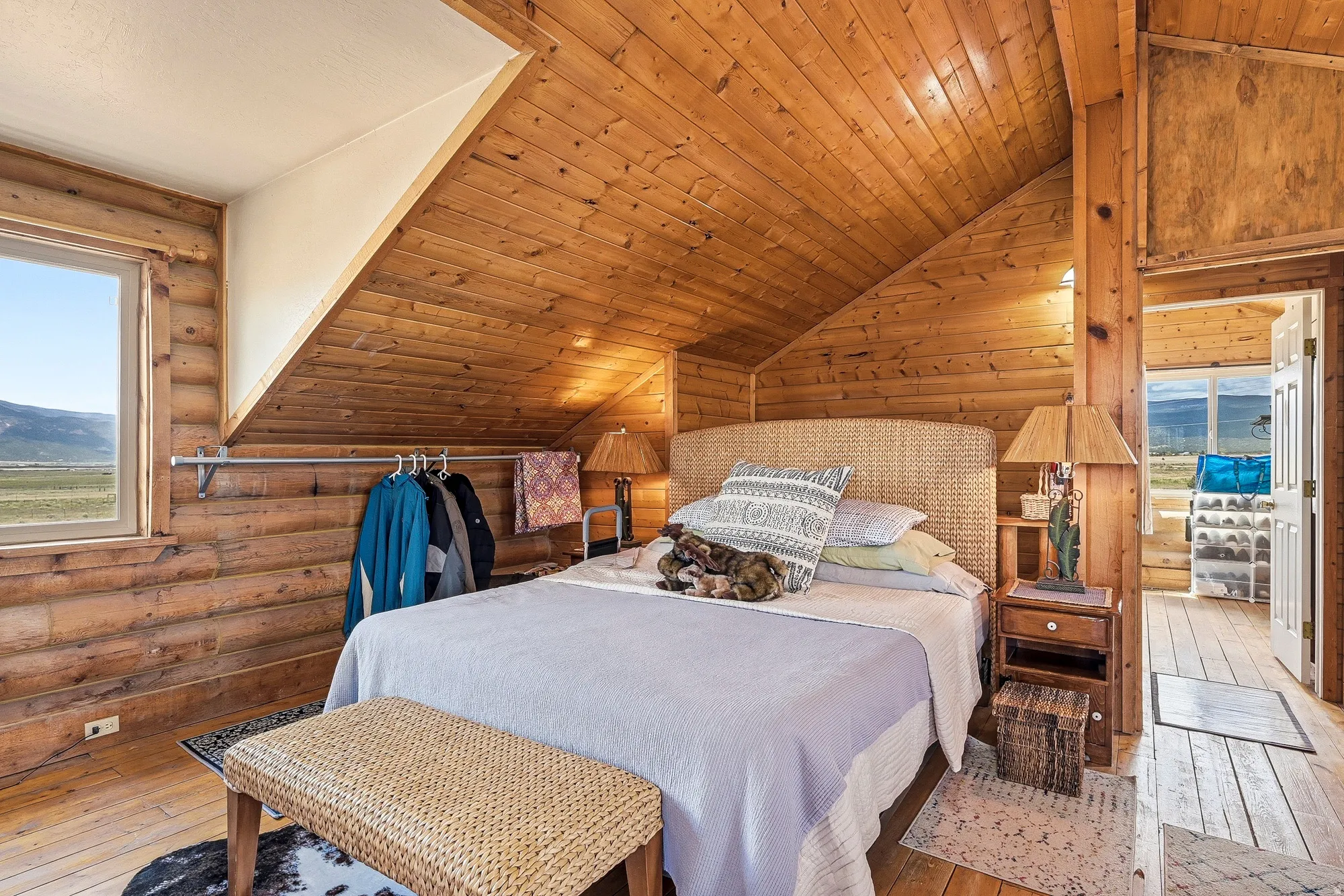 Room featuring extensive wood-paneled walls and ceiling, wood-finish flooring, and a window with outdoor scenery