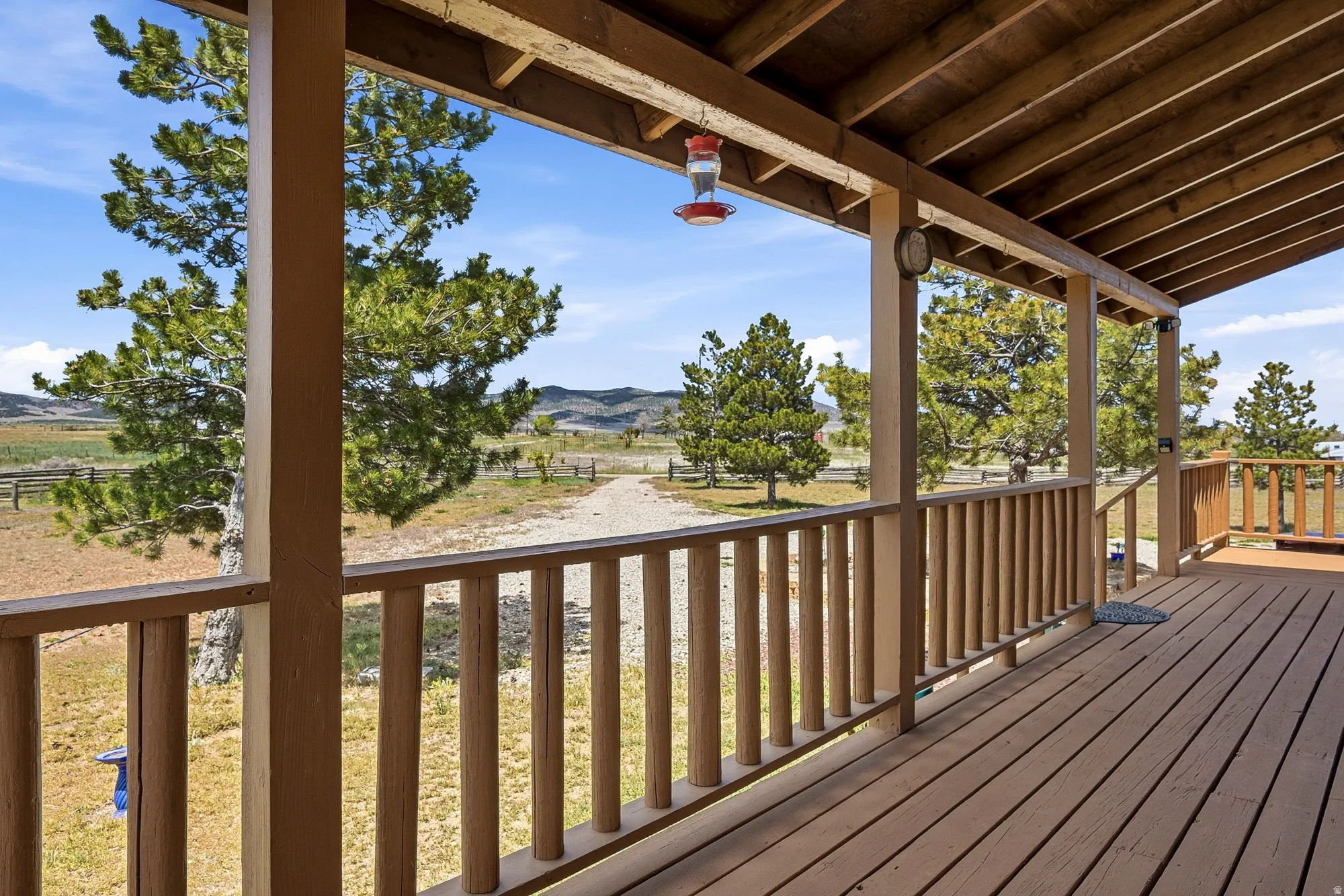 Expansive covered porch featuring wood-finish decking and railing