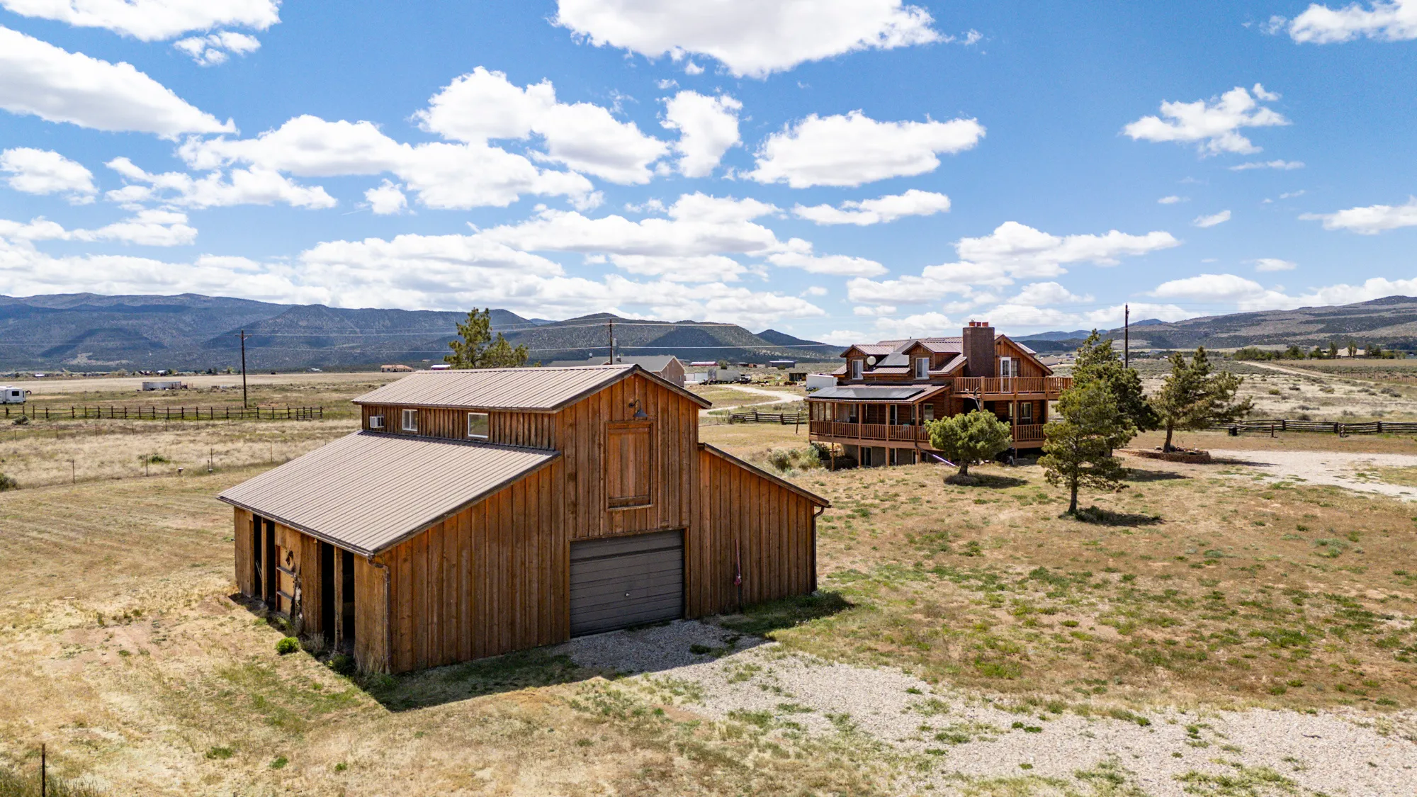 Expansive property featuring a rustic wood-sided barn with a metal roof and an integrated garage door