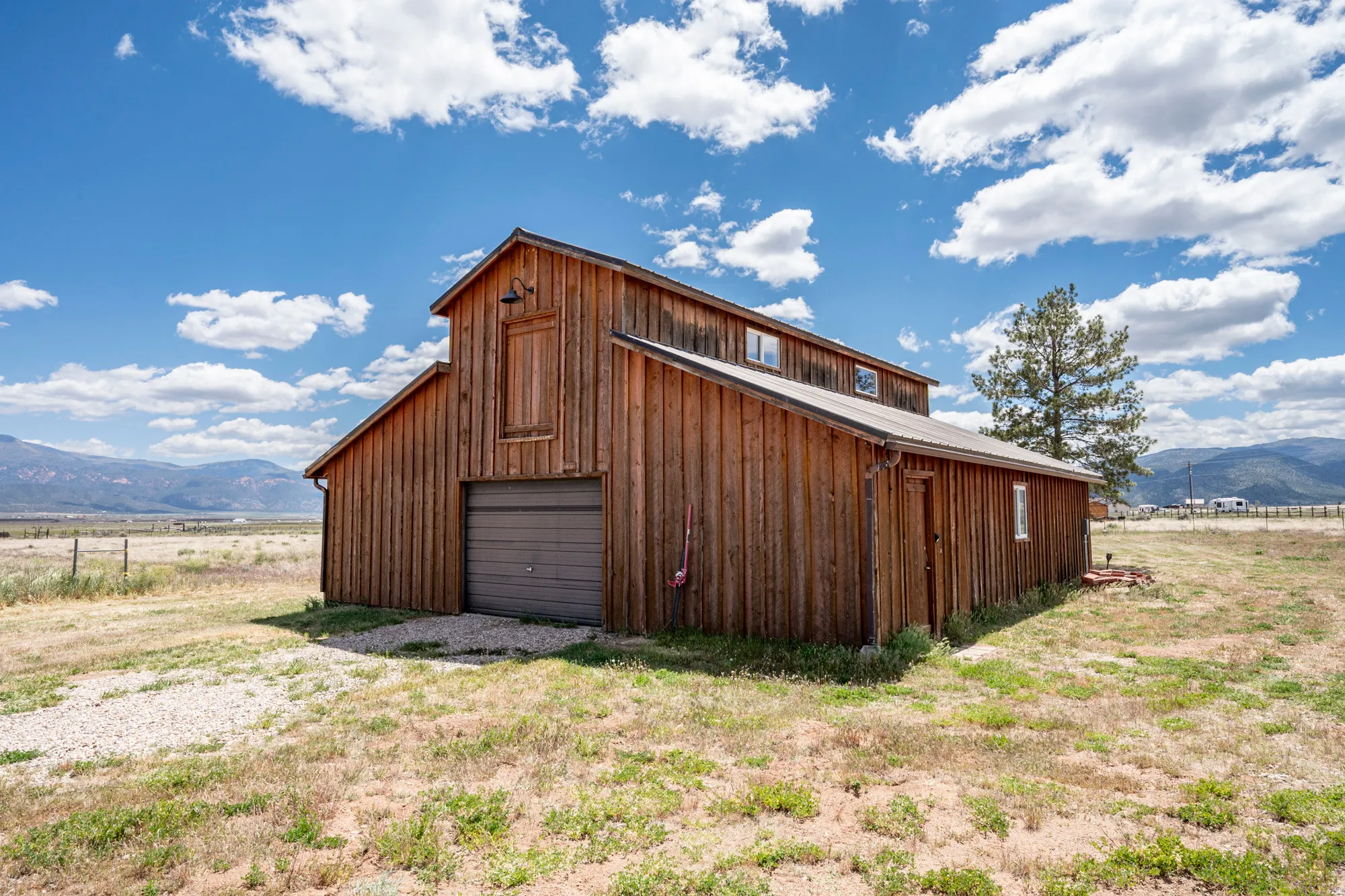 Wood-sided barn structure featuring a brown garage door