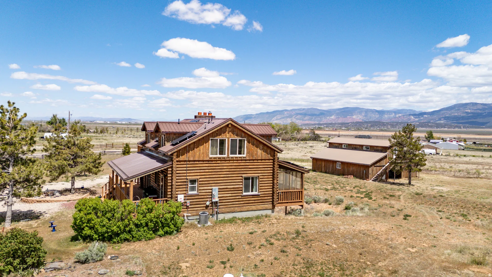 Log cabin-style residence featuring a covered porch, multiple dormer windows, and a metal roof