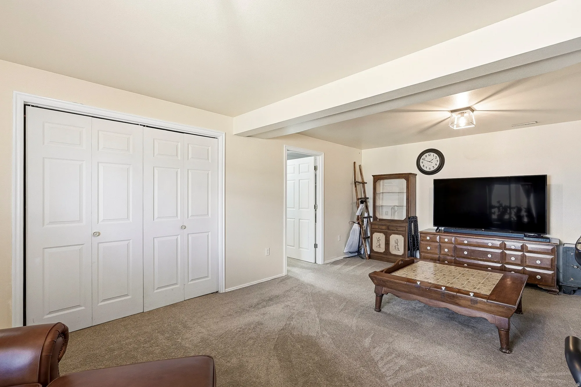 Wall-to-wall carpeting and white bi-fold closet doors provide functional storage