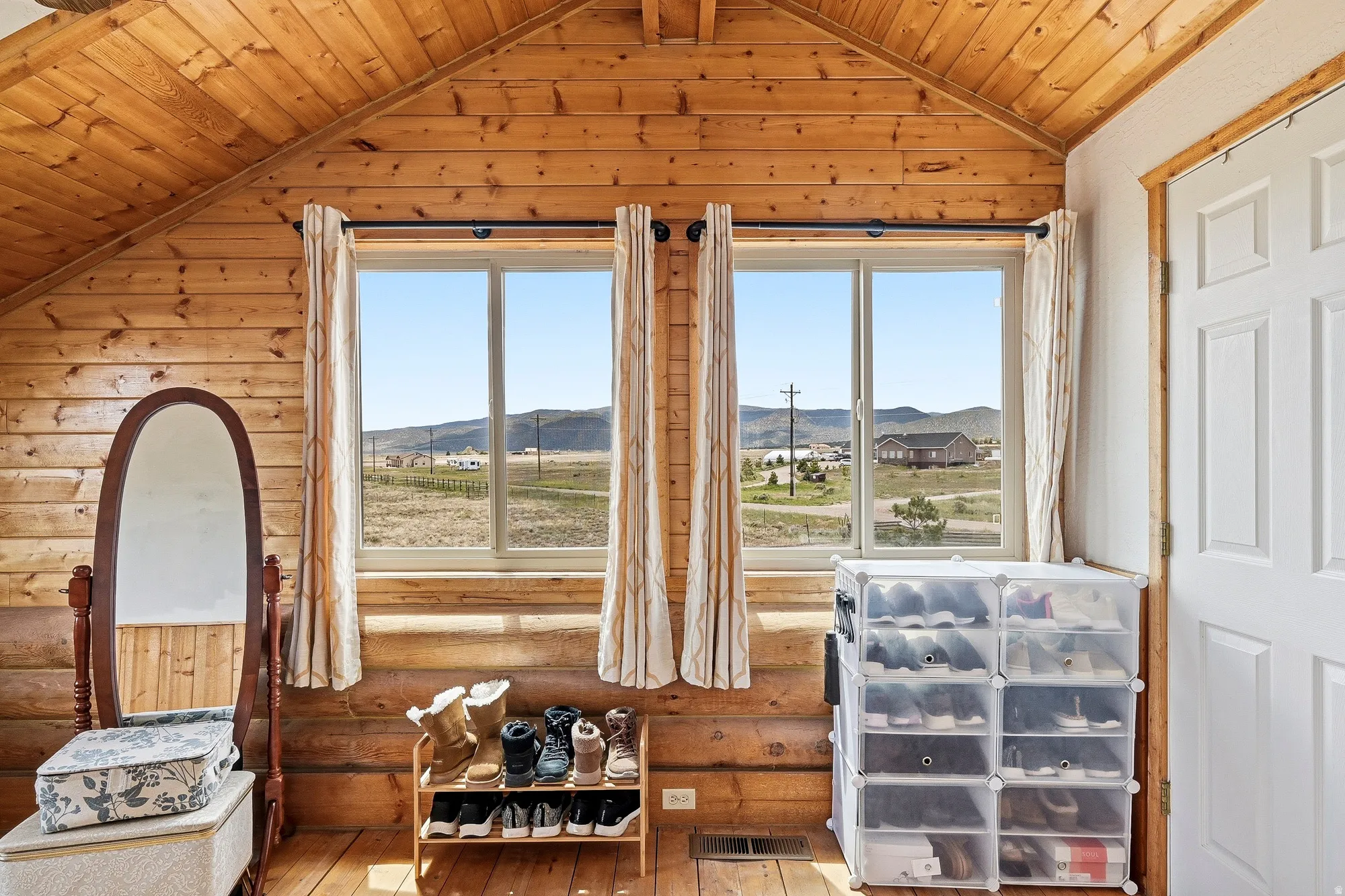 Wood-paneled room featuring a vaulted ceiling and wood-finish flooring