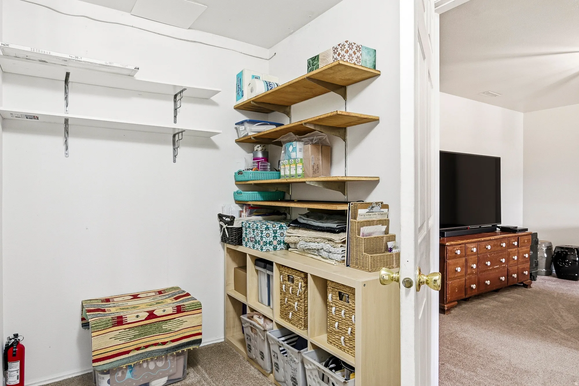 Dedicated storage space featuring a combination of wall-mounted shelving and a cubby storage unit