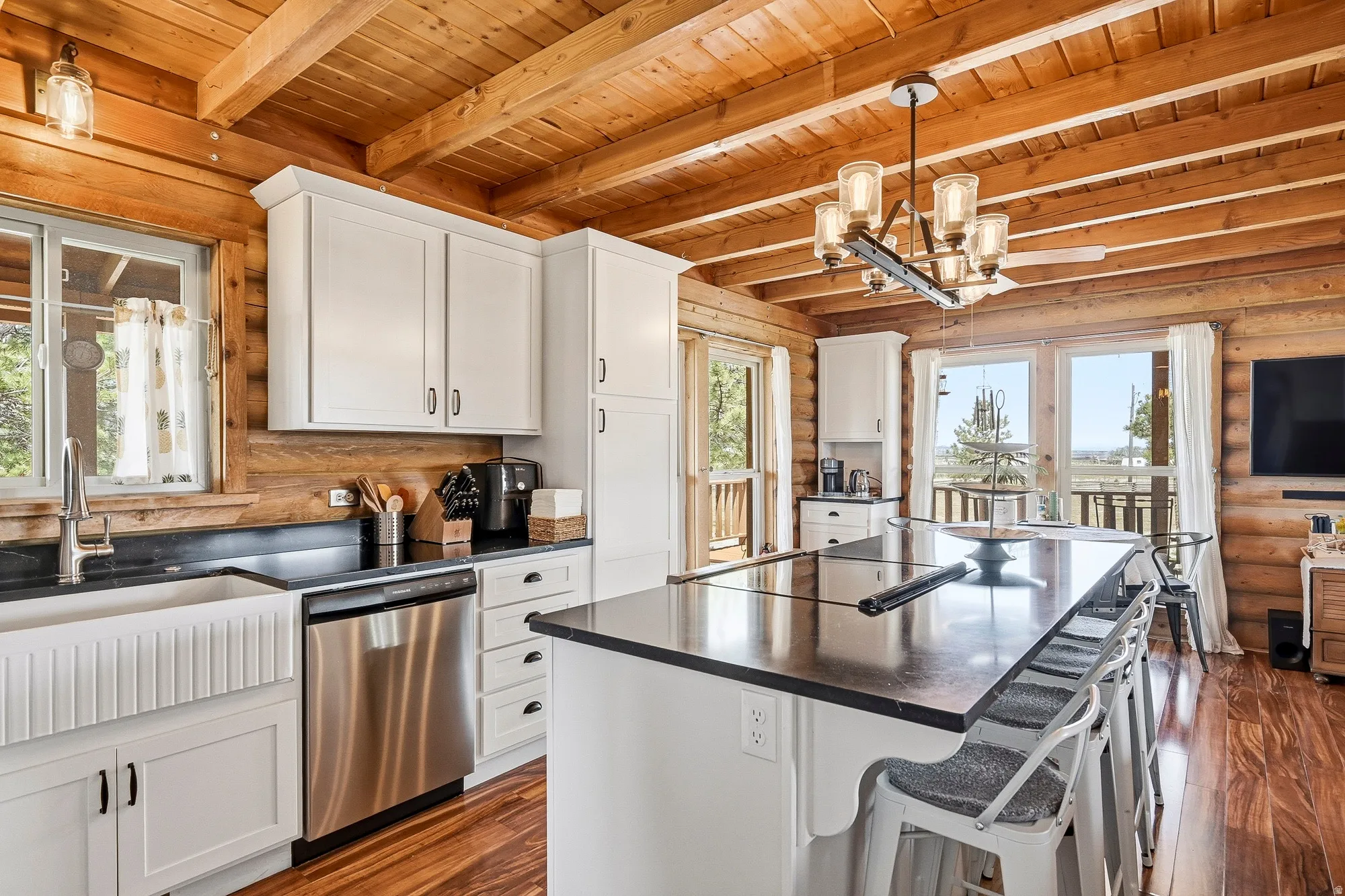 Modern kitchen featuring exposed wood beam ceilings and wood-finish flooring