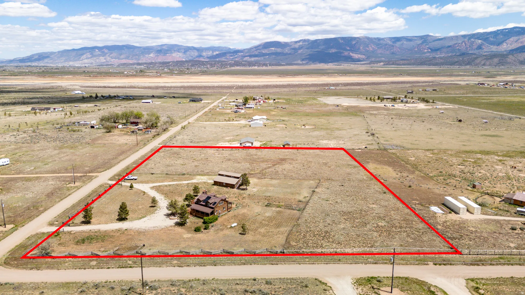 Expansive rural property featuring a large land parcel, established structures, and a natural landscape