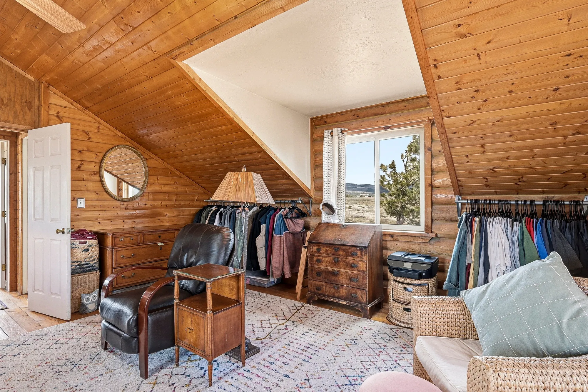 Room featuring natural wood plank walls and sloped ceiling