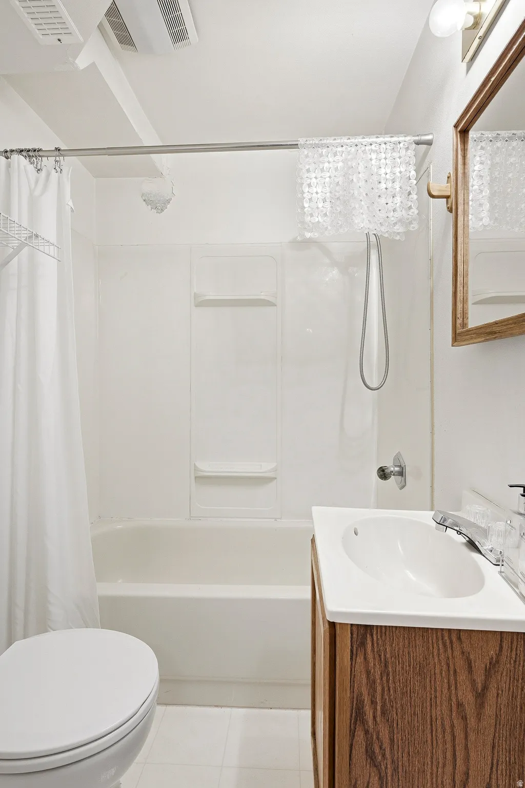 Bathroom featuring a white bathtub and shower combination with a showerhead and handheld sprayer