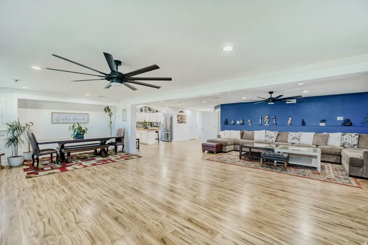 Open-concept living space featuring wood-finish flooring, recessed lighting, and dual ceiling fans