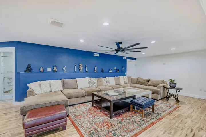 Spacious common area with a built-in display shelf, recessed lighting, and wood-finish flooring, extra large ceiling fan