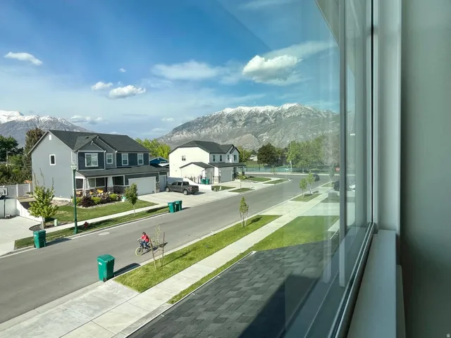 Expansive windows providing abundant natural light and showcasing a residential street with distant snow-capped mountains